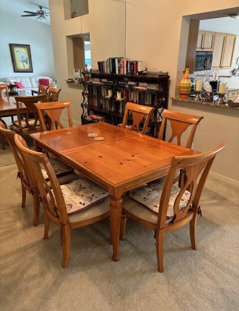 Wooden dining table with six chairs in a cozy room.