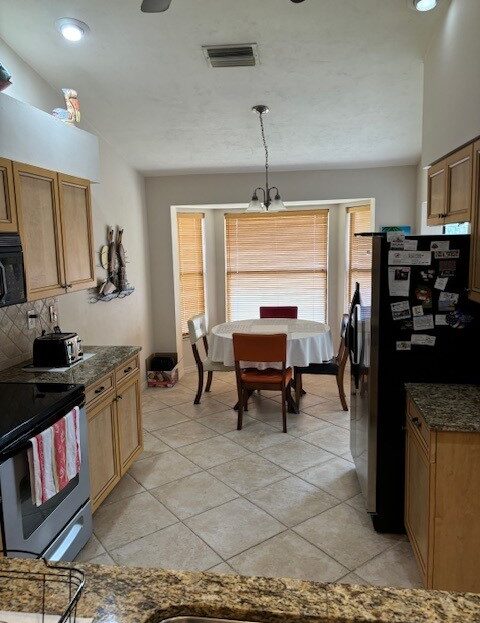 Cozy kitchen with wooden cabinets leading into a dining area with a table and chairs.