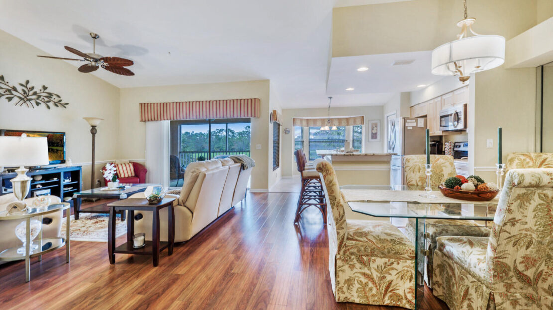 Spacious living area with hardwood floors and large windows.