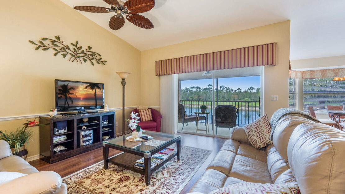 Cozy living room with lake view and ceiling fan.