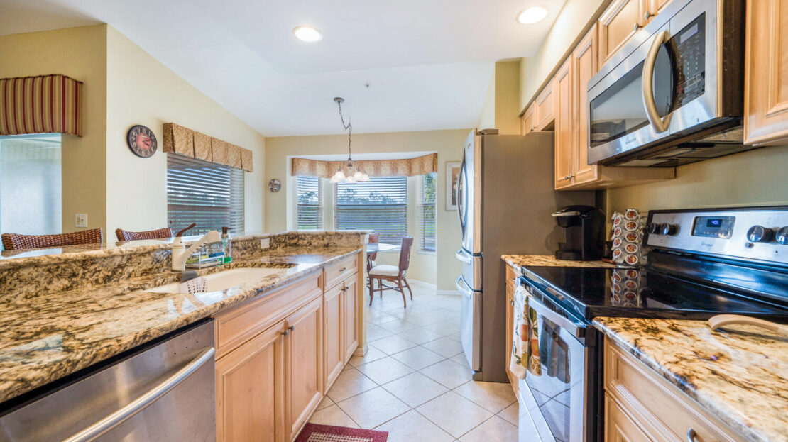 Bright modern kitchen with wooden cabinets and granite countertops.