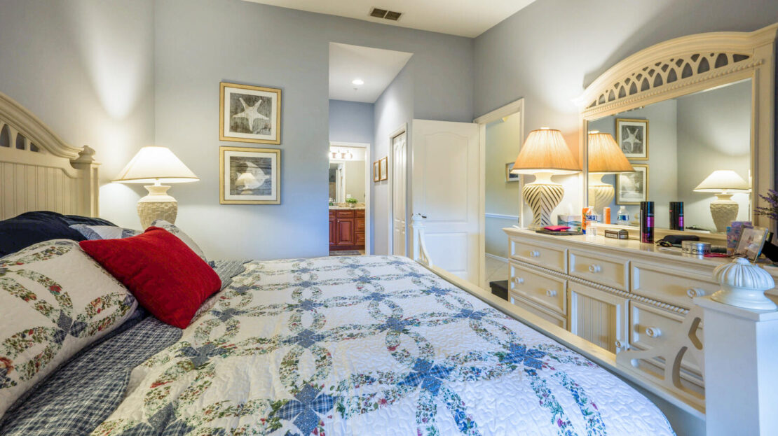 Cozy bedroom with floral bedding and soft lighting.