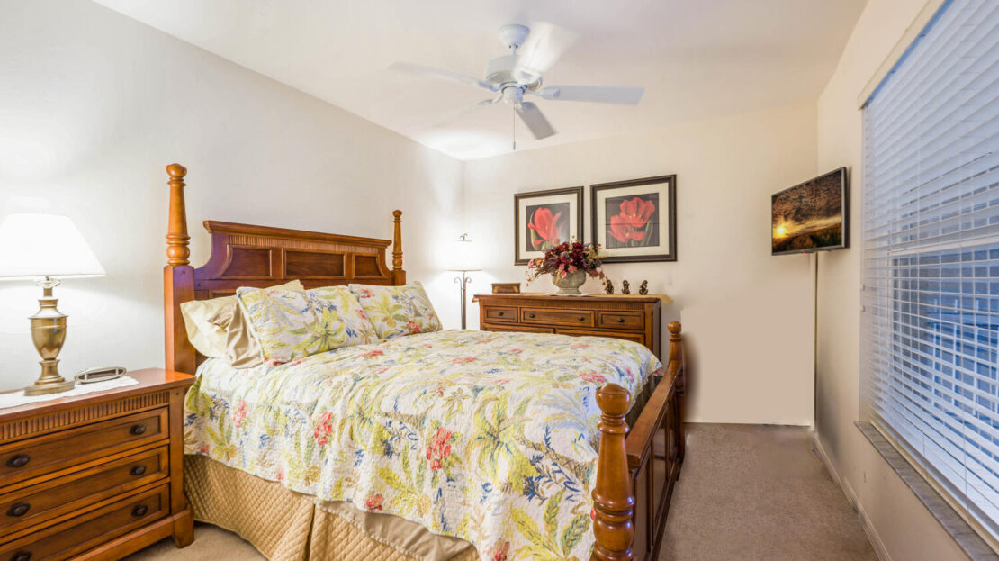 Cozy bedroom with wooden furniture and floral bedding.