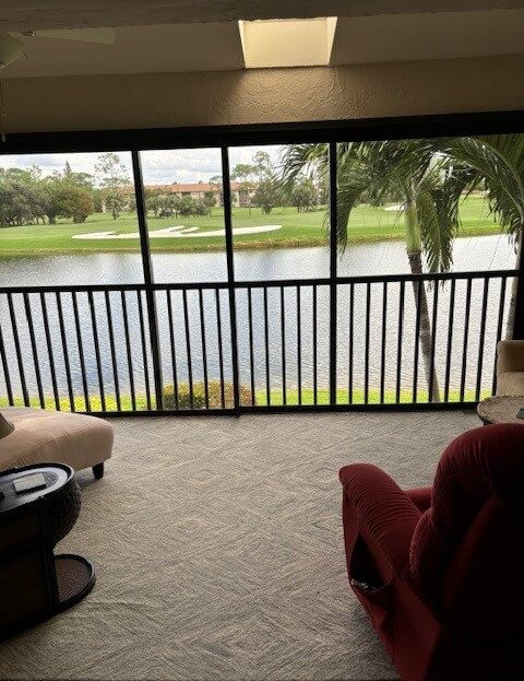 View from a cozy room overlooking a serene lake and green lawn.