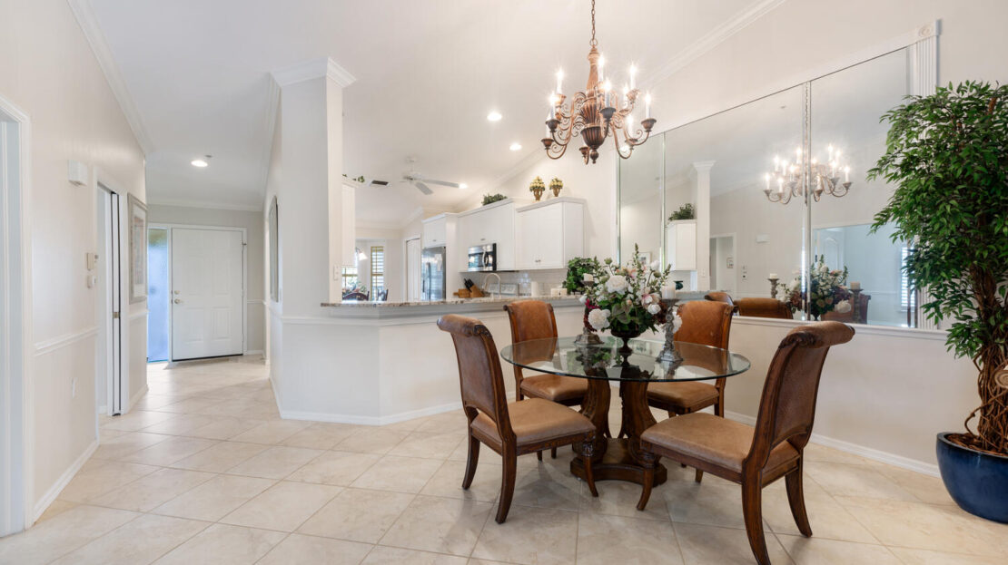 Elegant dining area with wooden table and chandelier lighting.