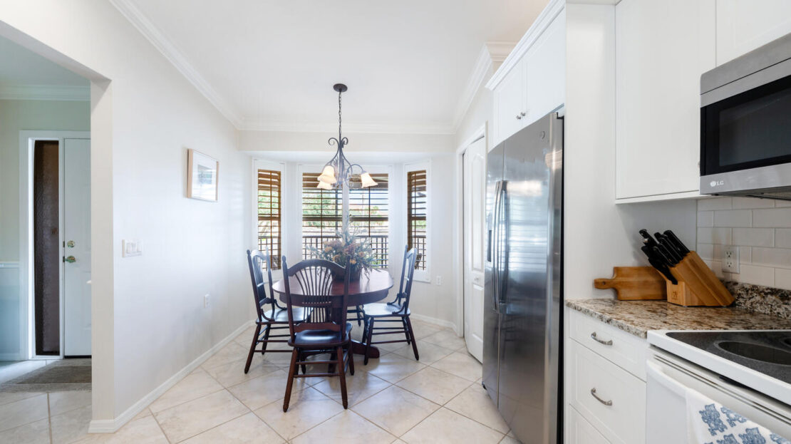 Bright kitchen dining area with a round table and black chairs.