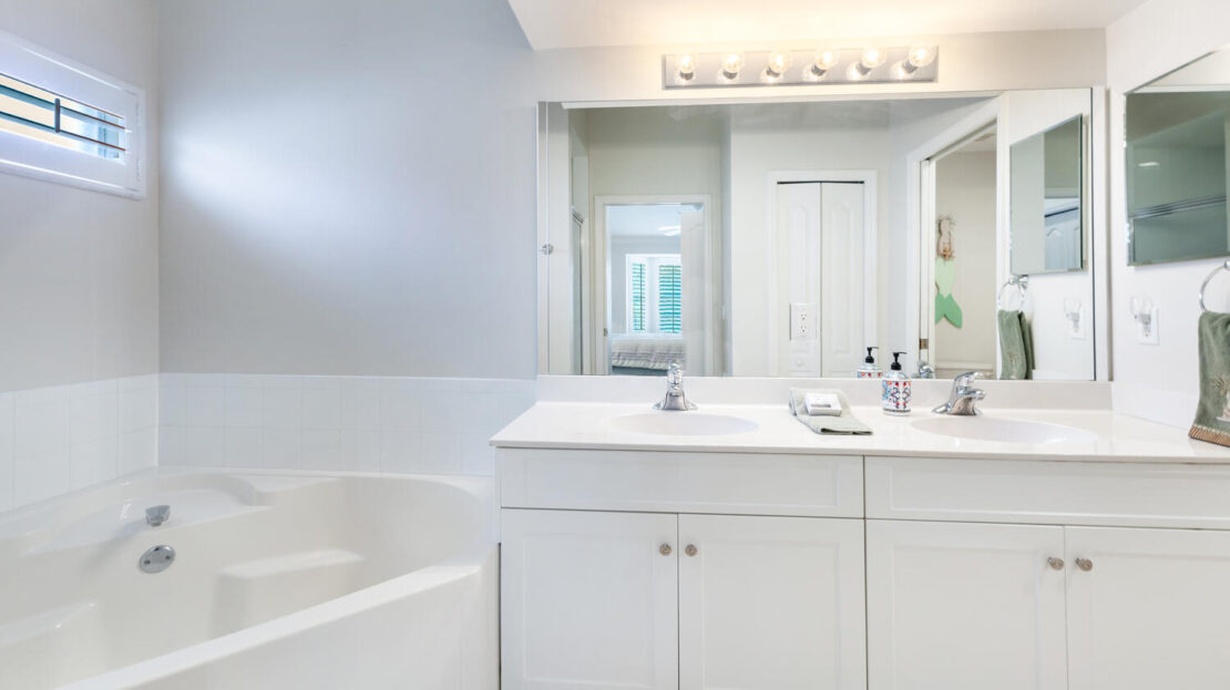 Bright bathroom with white fixtures and modern lighting.