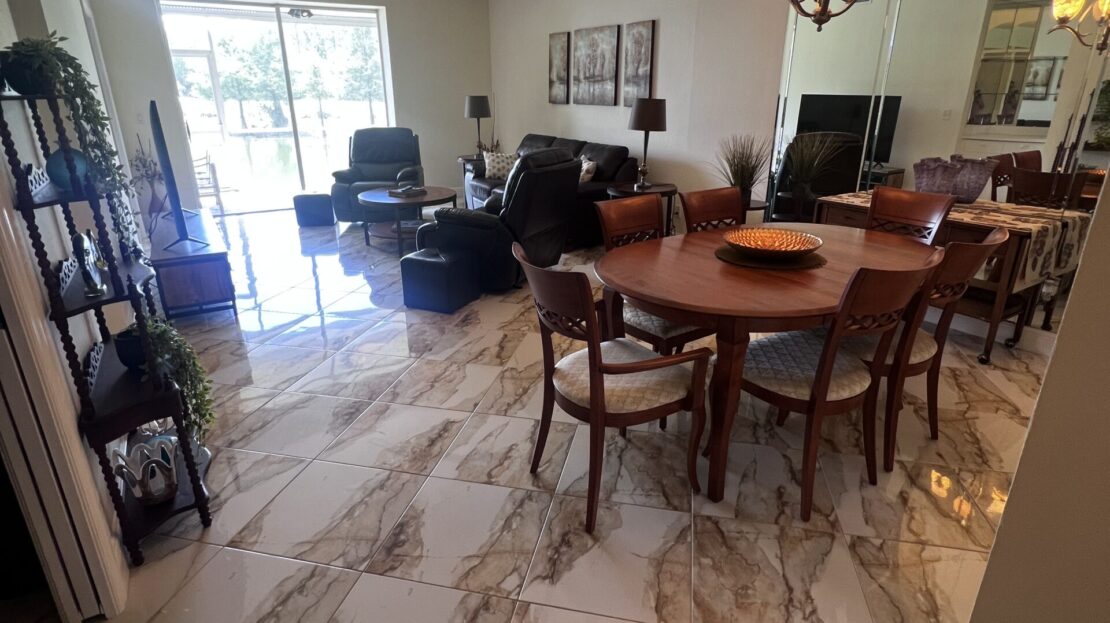 Spacious dining and living area with elegant marble flooring and modern furnishings.