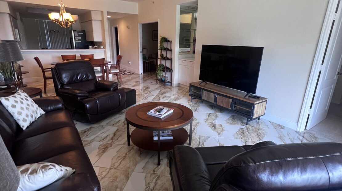 Cozy living room with leather sofas and large TV.