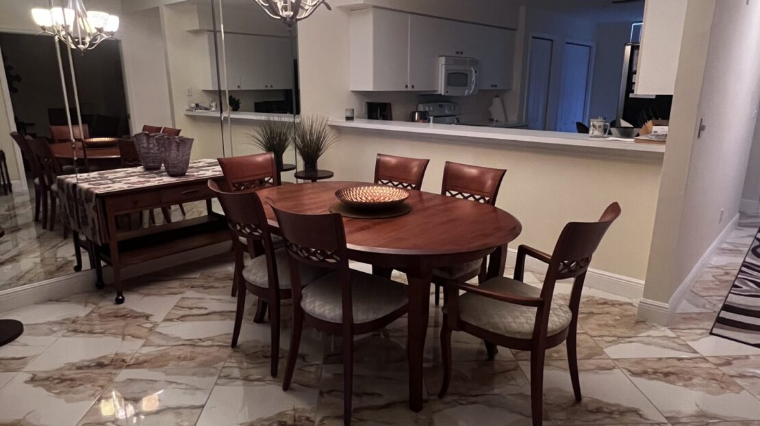 Elegant dining room with wooden table and marble floors.