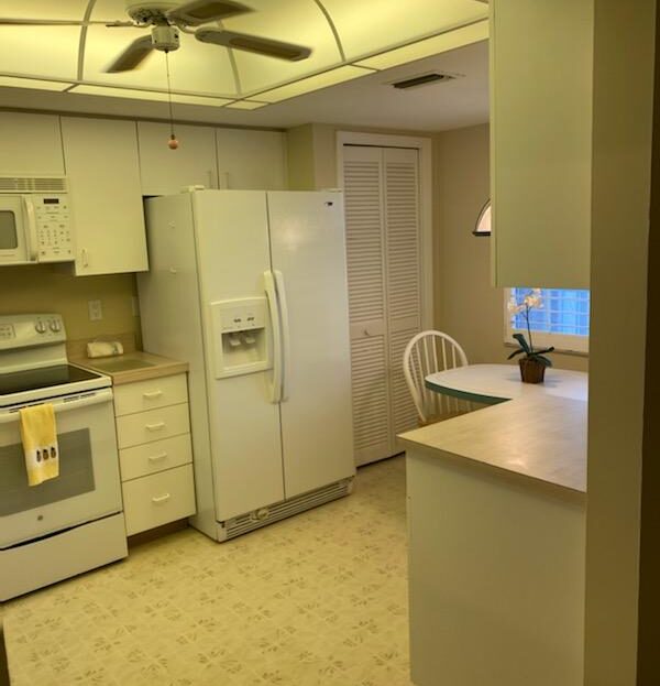 Cozy kitchen with white appliances and a small breakfast nook.
