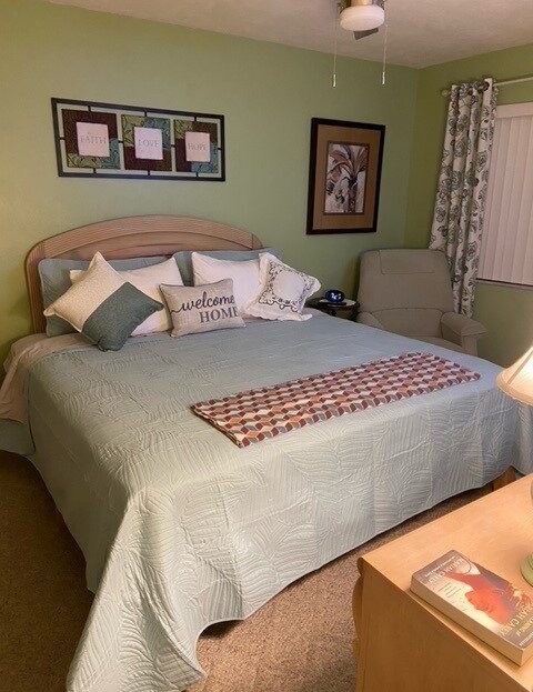 Cozy bedroom with a neatly made bed and soft green accents.