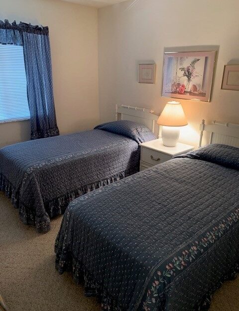 Cozy bedroom with two twin beds and soft lighting.