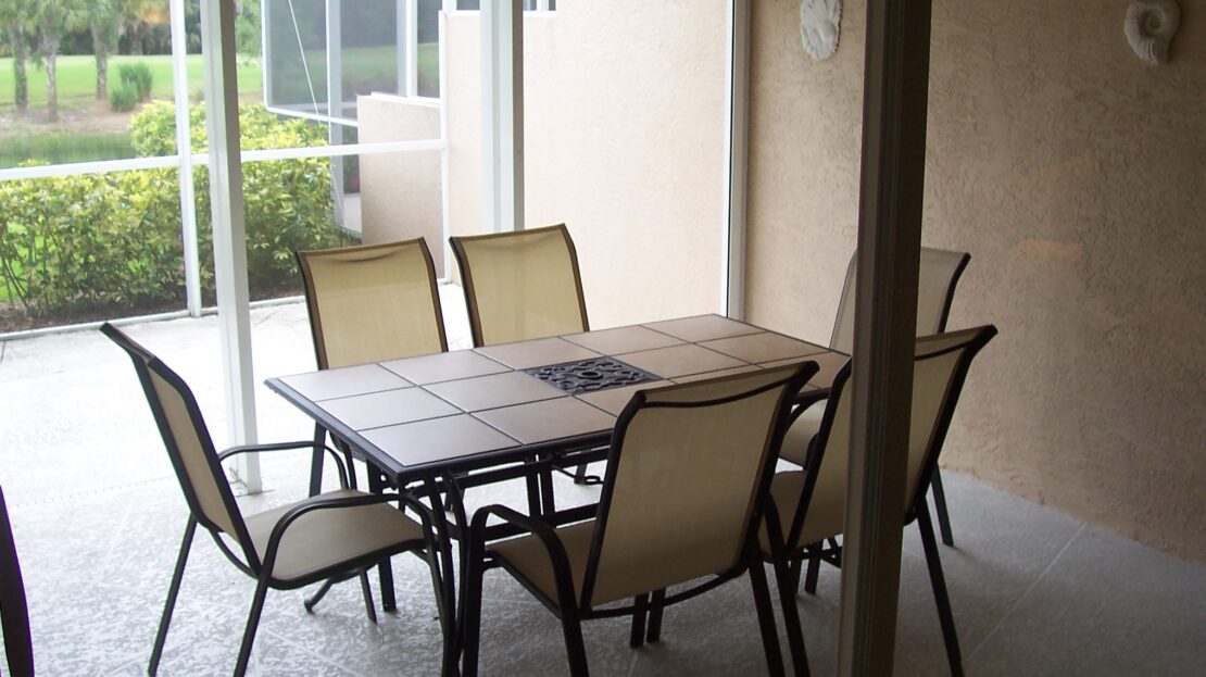 Outdoor patio dining set with six chairs and a rectangular table.