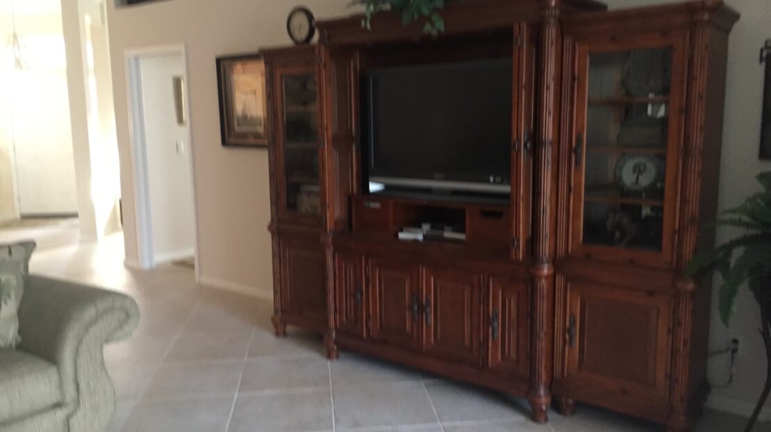 Elegant wooden entertainment center with TV and decorative items.
