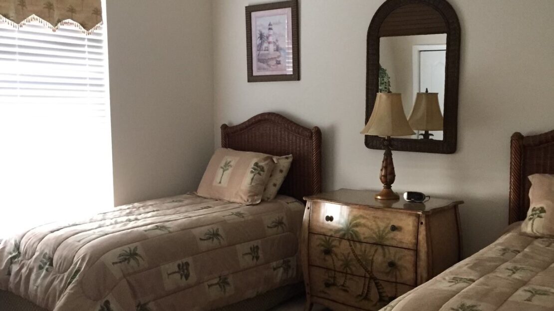 Cozy bedroom with two twin beds and warm decor.