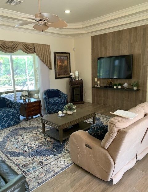 Cozy living room with blue armchairs, beige sofa, and a large TV.