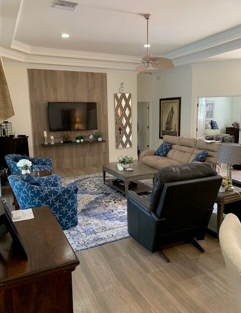 Cozy living room with varied seating and a TV on a wooden stand.