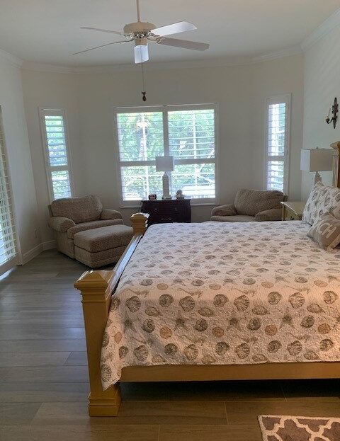 Cozy bedroom with a wooden bed and two armchairs by the window.