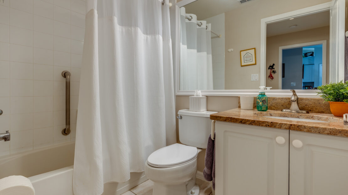 Clean bathroom with a shower curtain, toilet, and vanity.