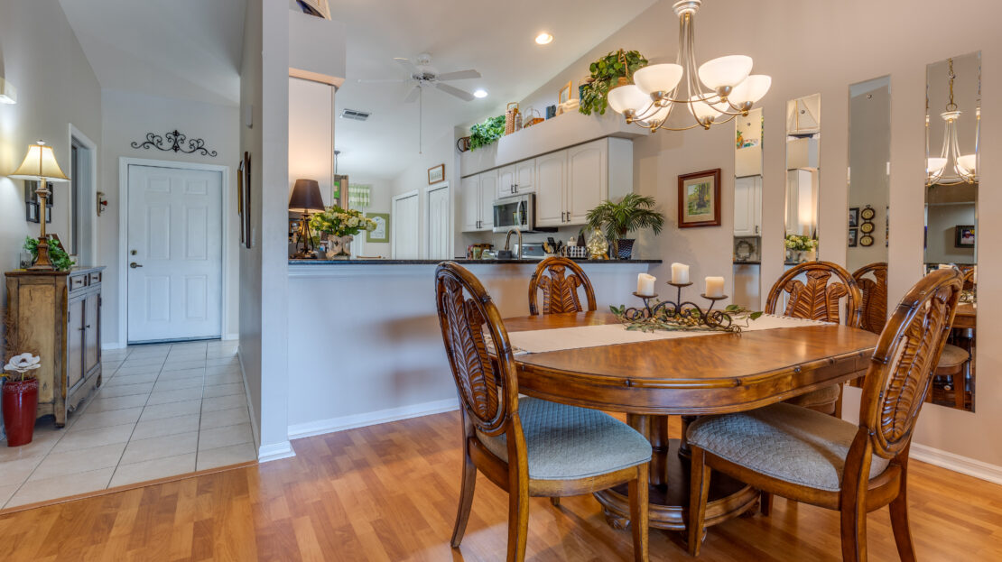 Cozy dining area with wooden table and chairs adjacent to a modern kitchen.