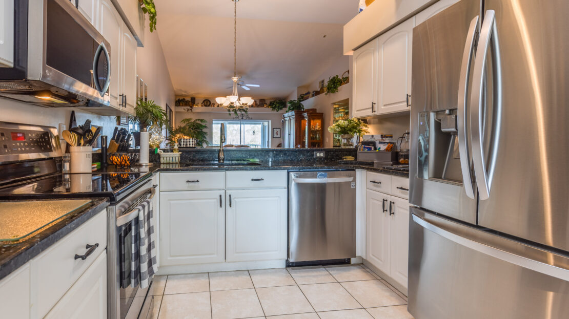 Modern kitchen with stainless steel appliances and white cabinetry.