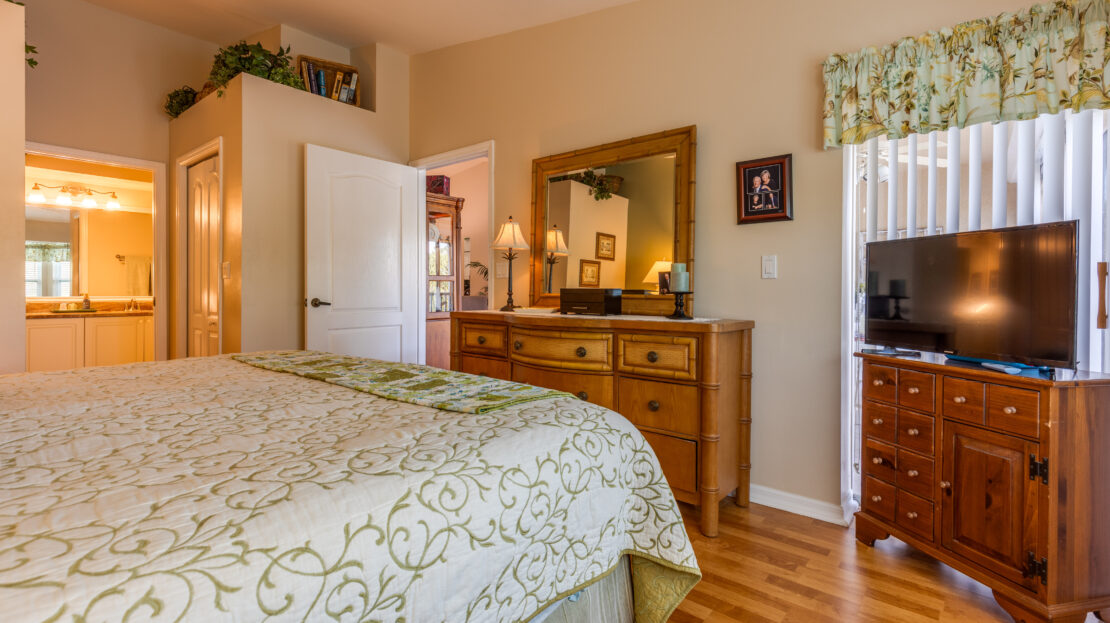 Cozy bedroom with wooden furniture and warm lighting.