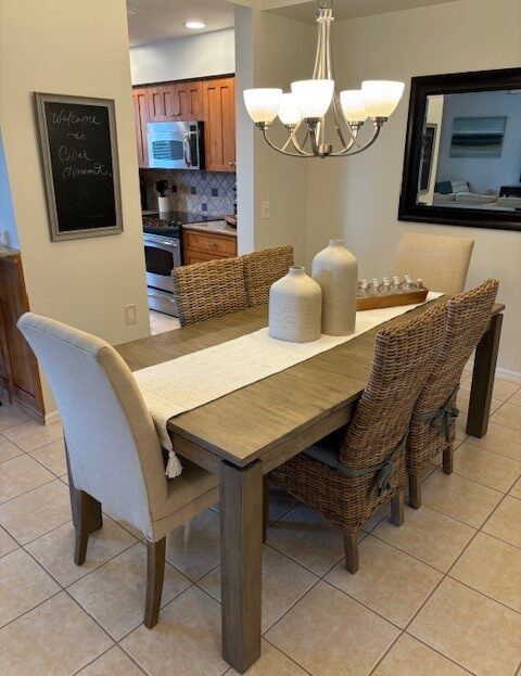 Elegant dining table set with wicker chairs and decorative vases.