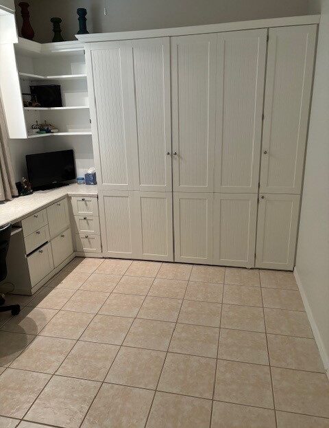 A clean, well-organized laundry room with cabinets and appliances.