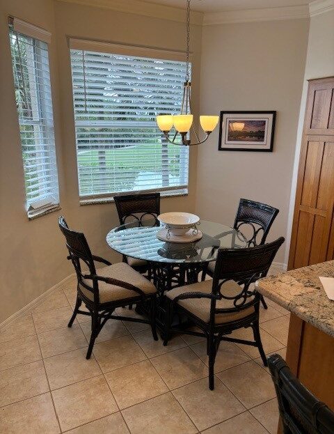 Cozy dining nook with glass table and four black chairs by large windows.