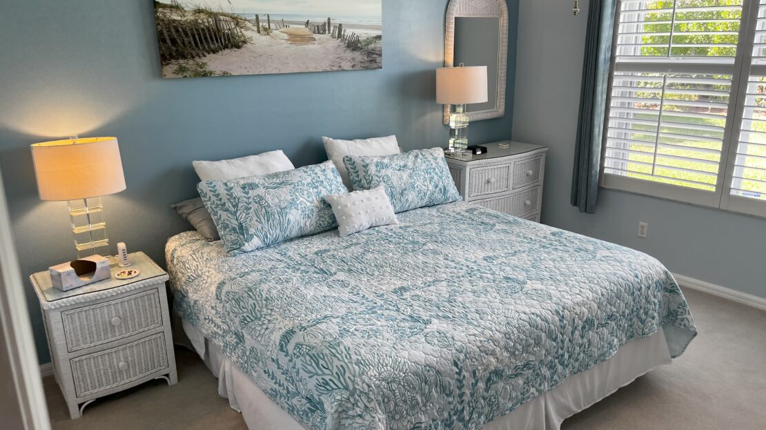 Cozy bedroom with patterned bedding and soft lighting.