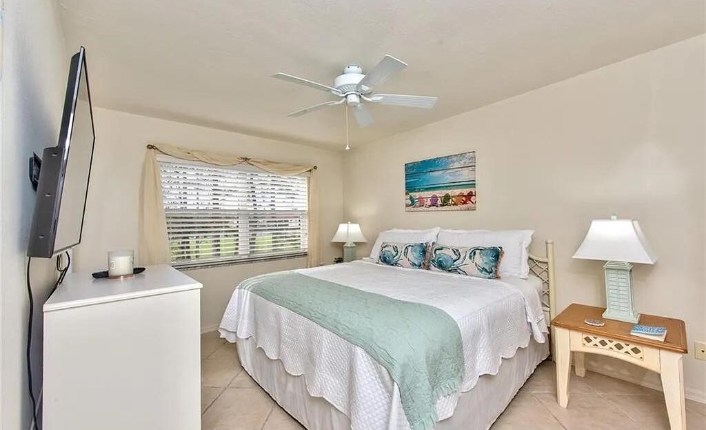 Bright bedroom with large window and coastal-themed decor.