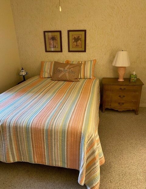 Cozy bedroom with a striped bedspread and wooden nightstand.