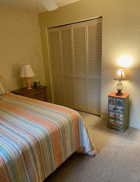 Cozy bedroom with striped bedspread and warm lighting.