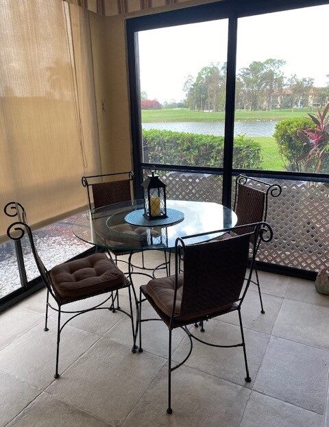 Cozy outdoor patio set with glass table and iron chairs.