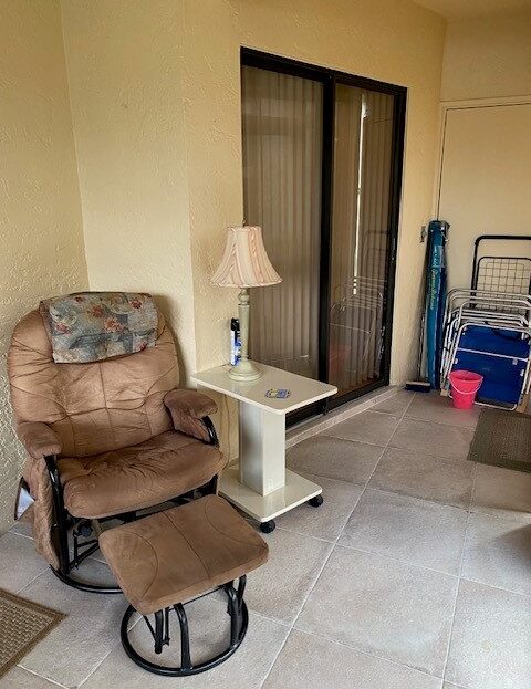 Cozy recliner and side table in a simple living space with a sliding door.