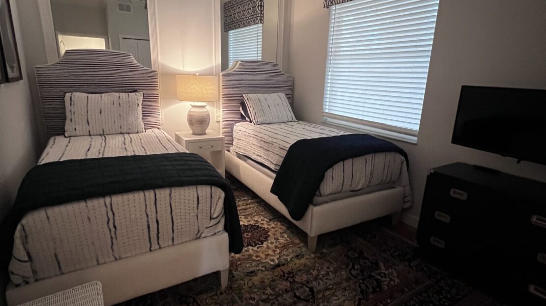 Cozy bedroom with twin beds and warm lighting.