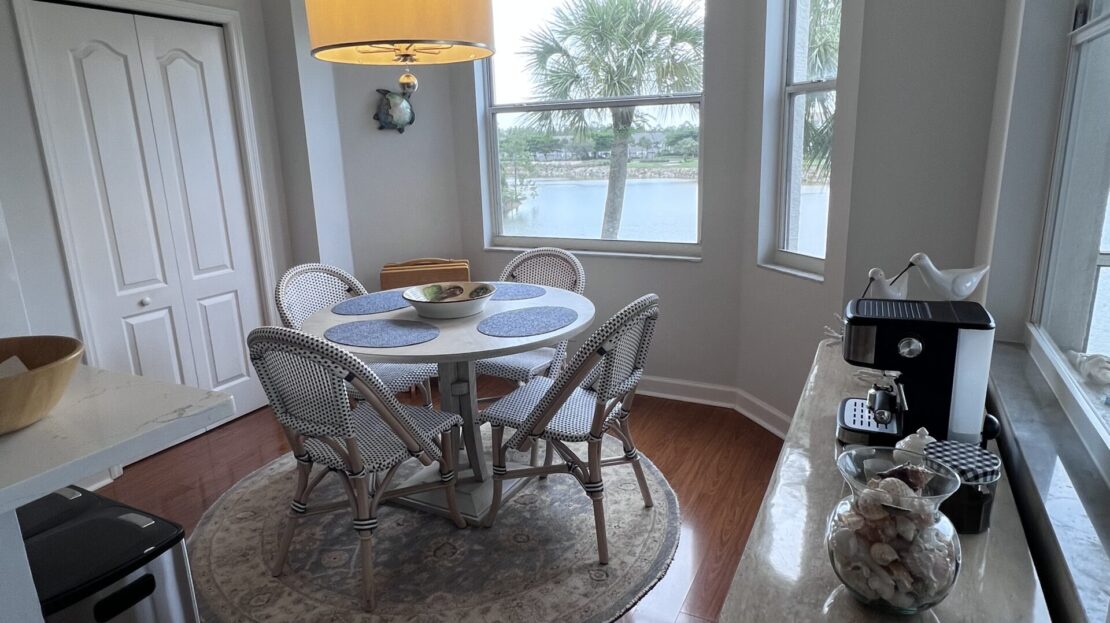 Cozy dining nook with round table and large windows.