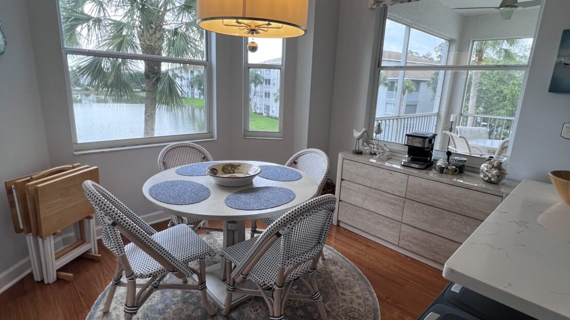 Cozy breakfast nook with round table and large windows.