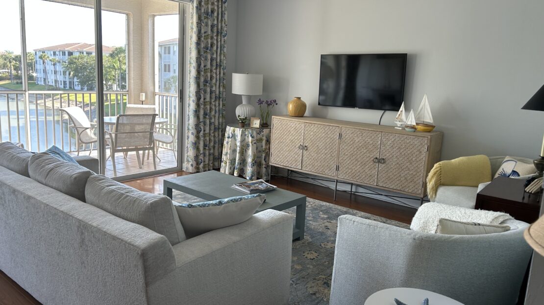 Modern living room with white furniture and outdoor view.