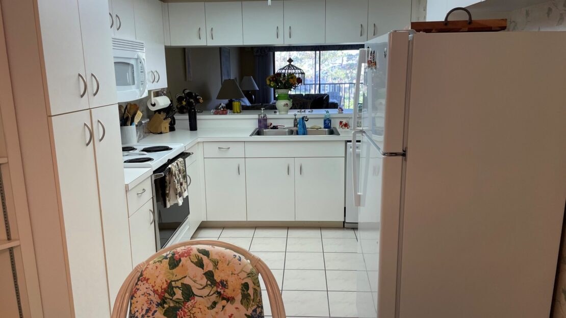 A cozy kitchen with white cabinets and a dining table.