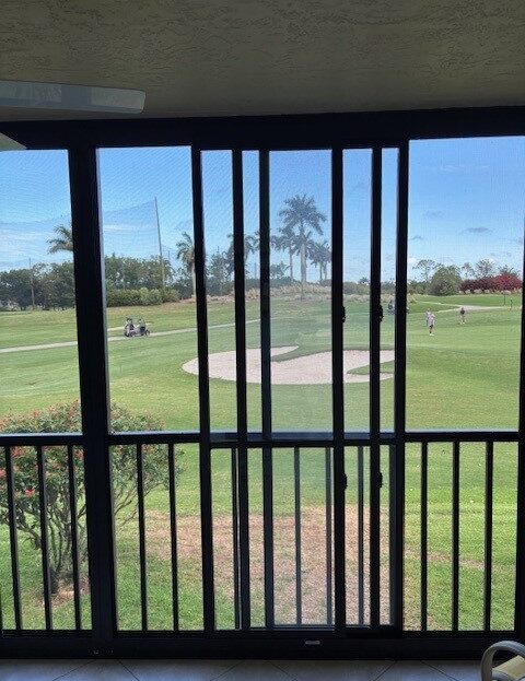 View from a balcony overlooking a golf course on a sunny day.
