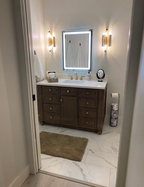 Modern bathroom vanity with illuminated mirror and elegant lighting.