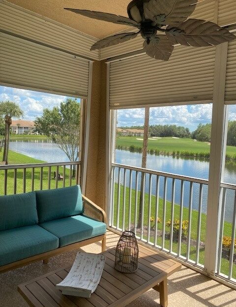 Cozy porch with seating overlooking a serene lake and golf course.
