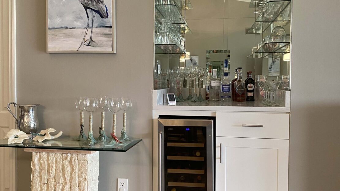 Elegant home bar setup with a wine fridge and decorative accents.