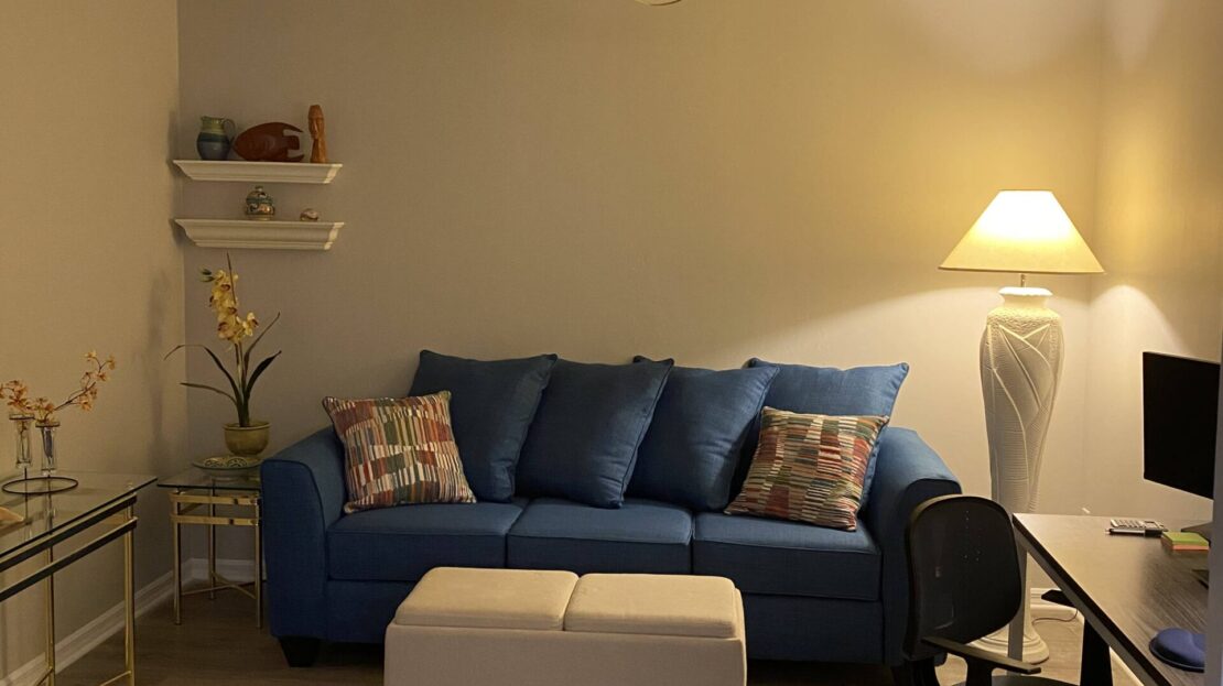 Cozy living room with blue sofa and soft lighting.