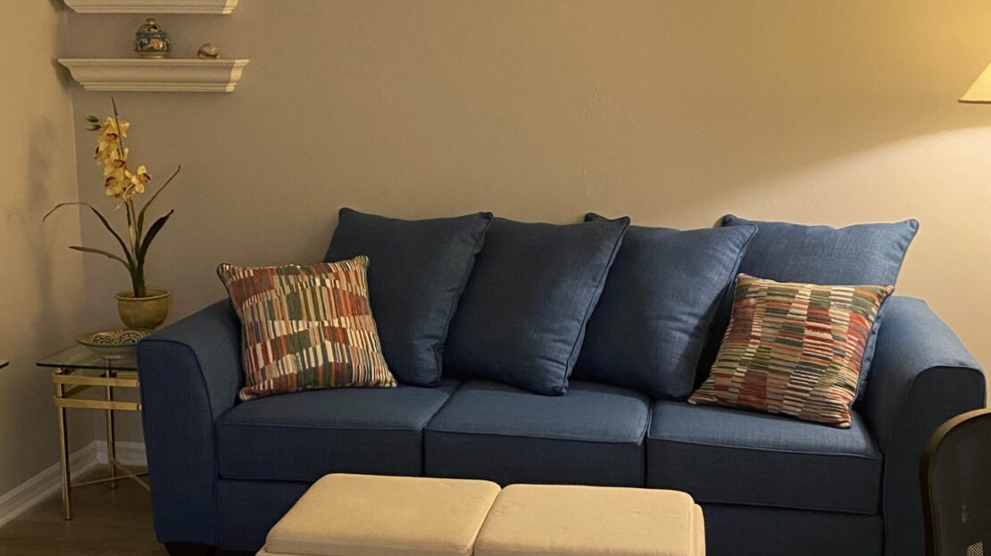 Cozy living room with a blue sofa and soft lighting.