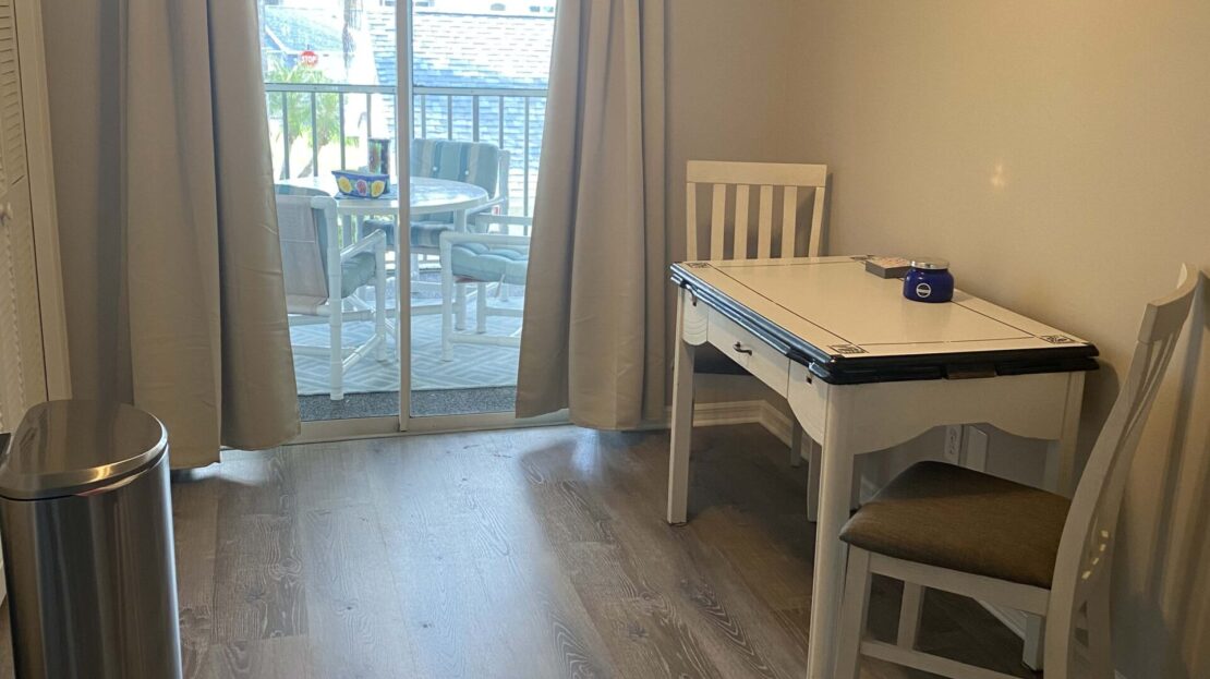 Bright room with dining table and sliding glass door to balcony.