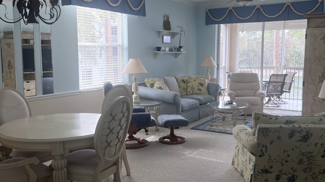 Bright living room and dining area with elegant furniture and large windows.
