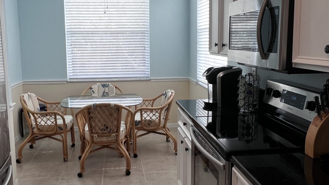 Cozy kitchen nook with wicker chairs and natural light.